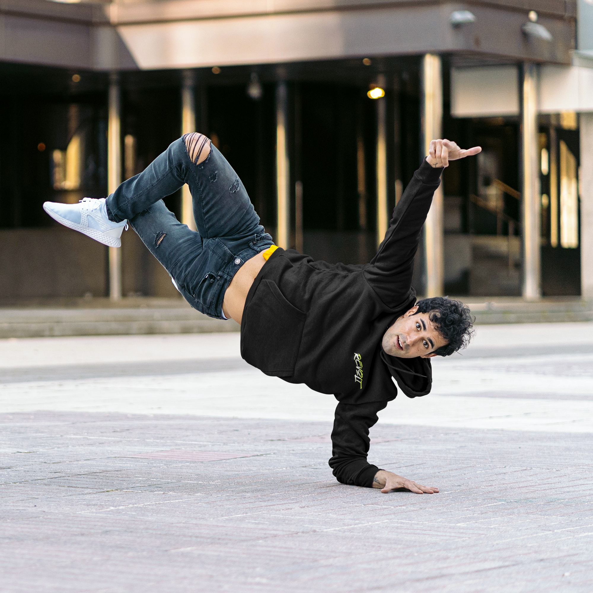 Man breakdancing in street with gym hoodie on