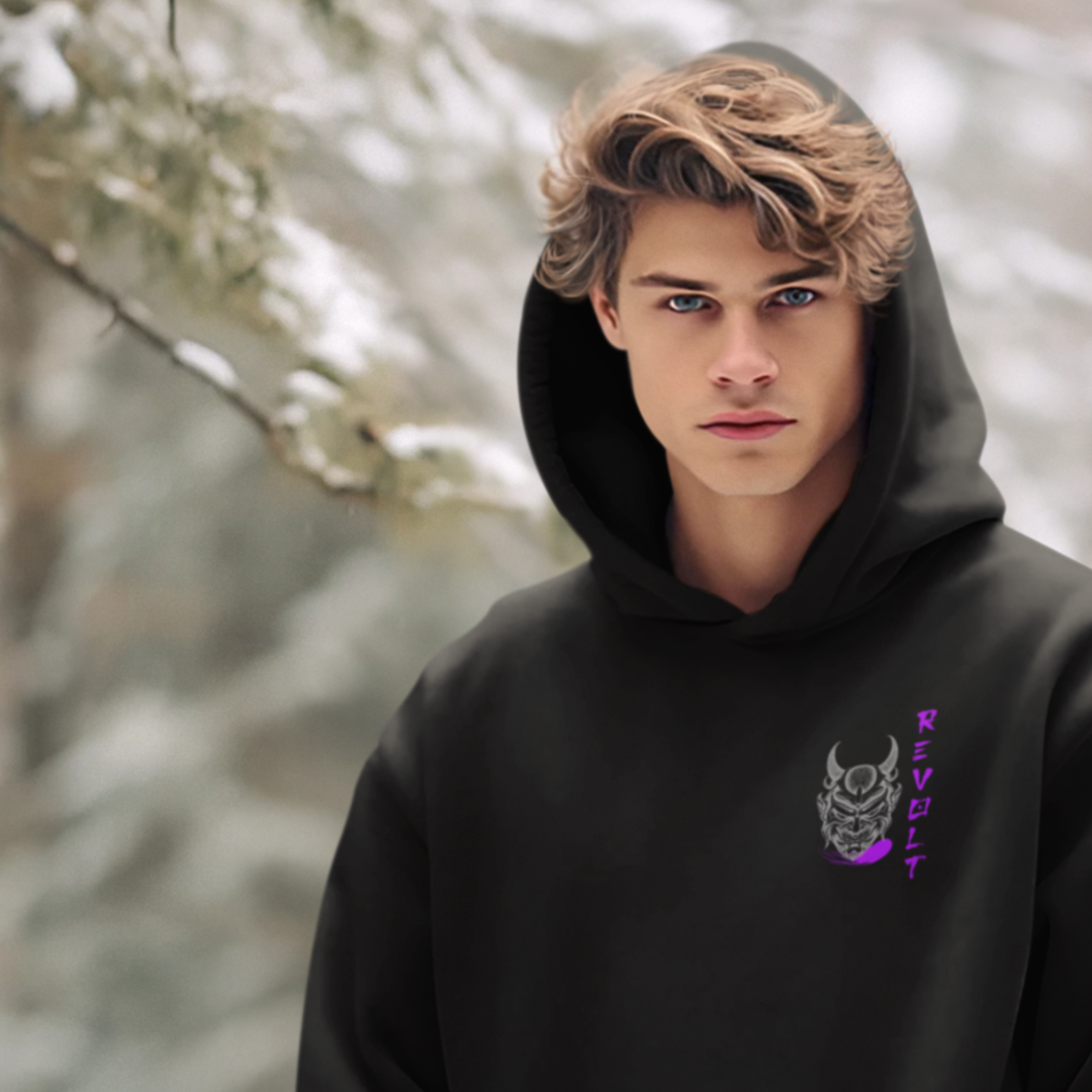 Man standing in a winter forest wearing a revolt gym hoodie with blonde hair